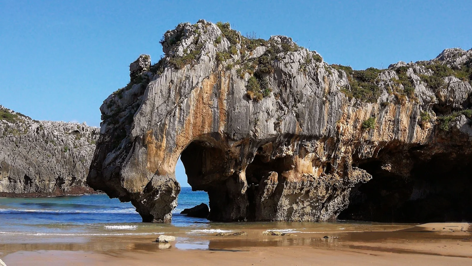 Beach with a rock arch on the coast of Asturias, Spain