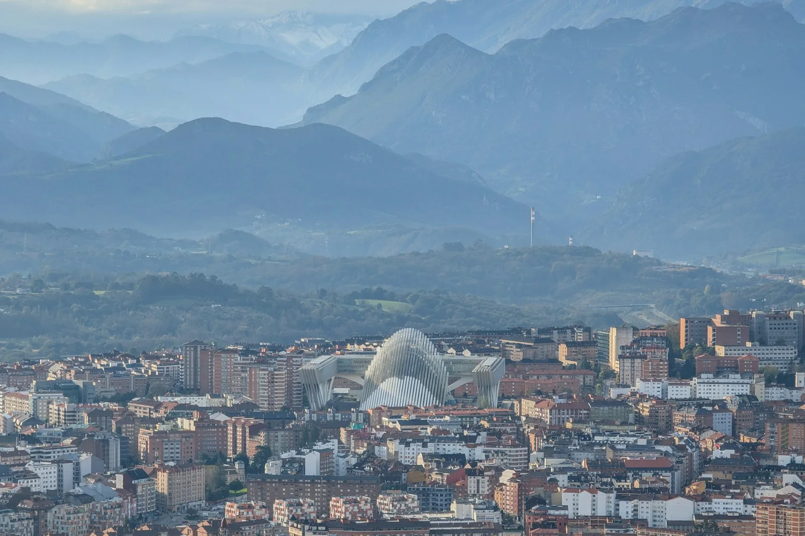 Vista de Oviedo con las montañas al fondo, una ciudad con barrios para vivir
