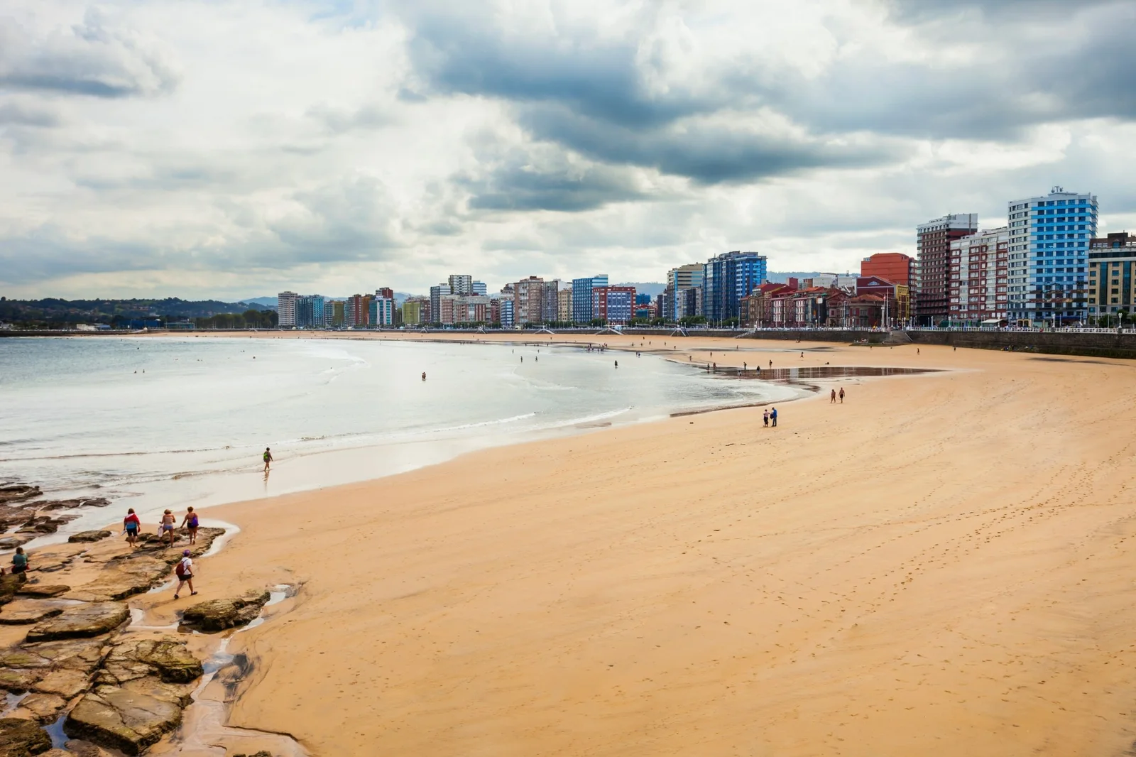 Playa de San Lorenzo en Gijón con la ciudad al fondo, una zona para vivir en Asturias